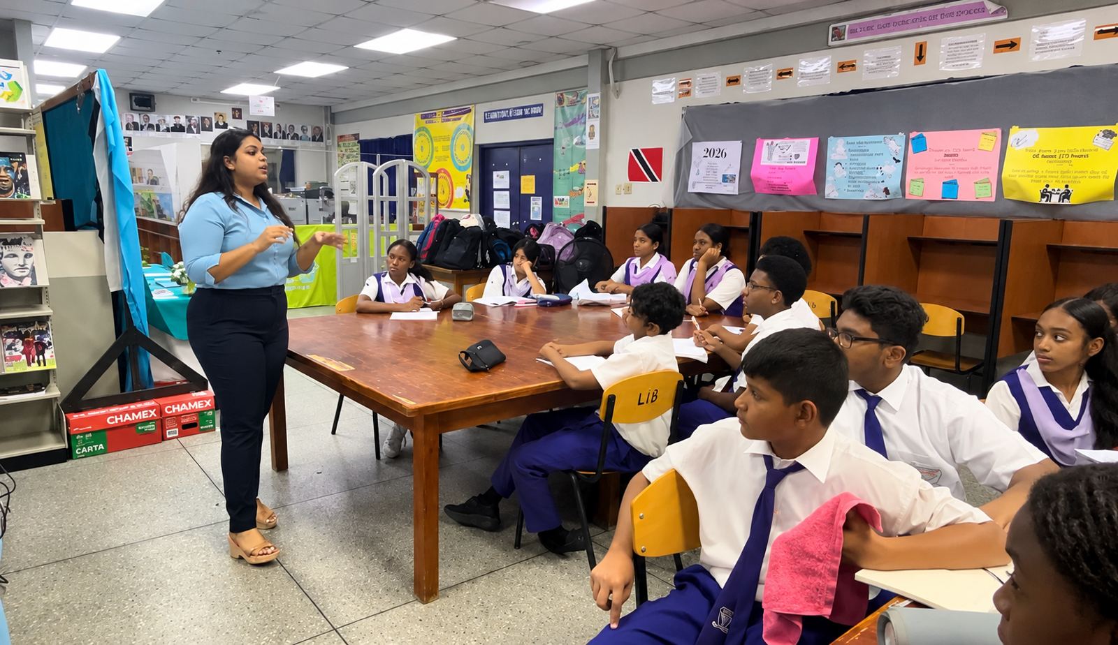 Rheanna teaching a group of students seated around a library table